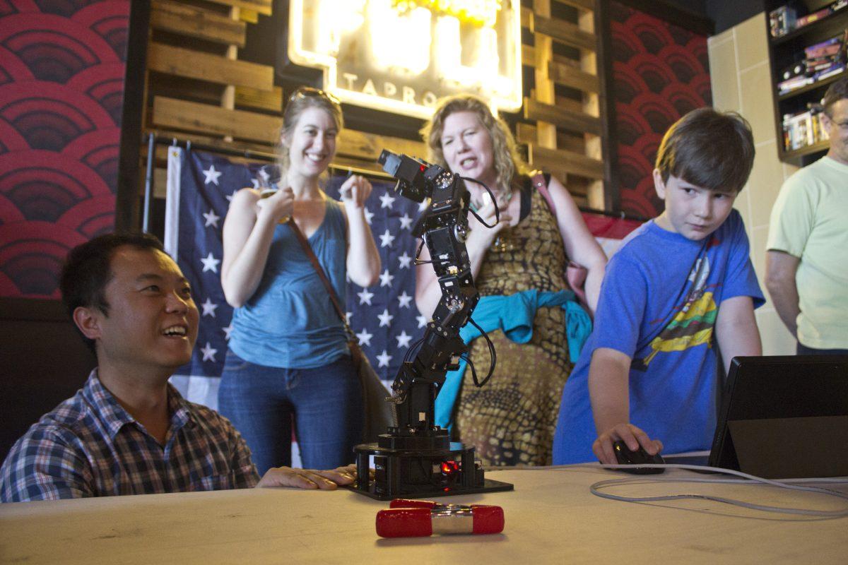 Connie Cheng | Photo Editor

Doctoral candidate Jingfu Jin demonstrates how a mechanized mini-arm works to moviegoers on June 27. Students and faculty from the School of Engineering and Computer Science hosted the event at Alamo Drafthouse.
