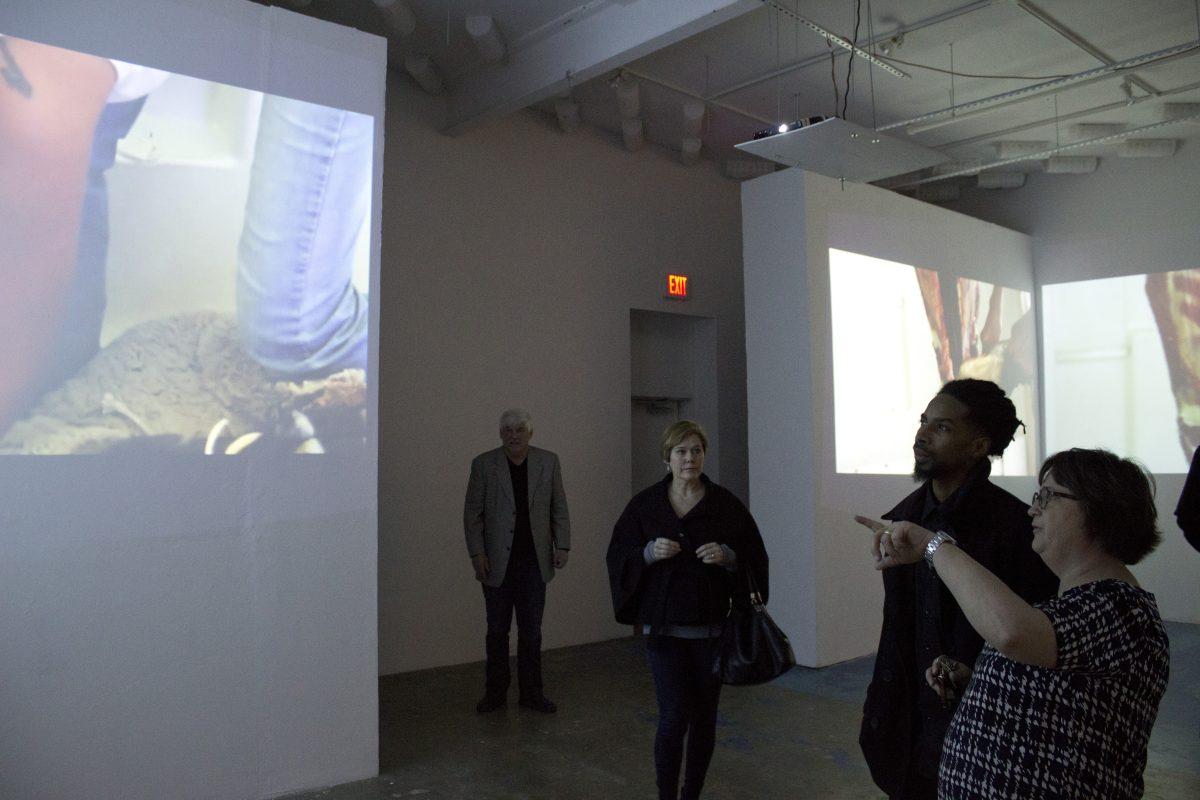 Marcelo Yates| Staff
Art showgoers observe the video installation created by Postcommodity, an internationally acclaimed Native American art collective who brought their exhibit to CentralTrak. The installation, titled “Gallup Motel Butchering,”  will be showcased through Feb. 21.