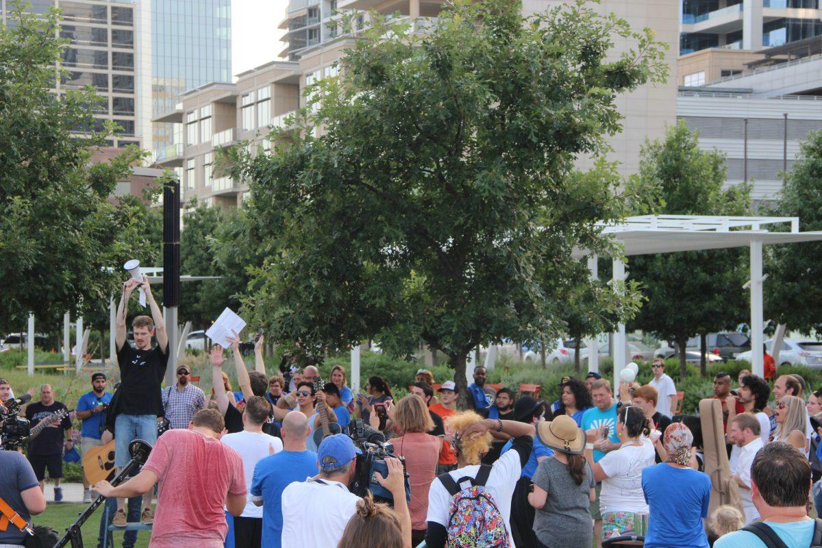 Andy Welker (left) raises his bullhorn to signify the beginning of "Love in the Streets," an event he helped organize to spread peace following the shooting on July 7.