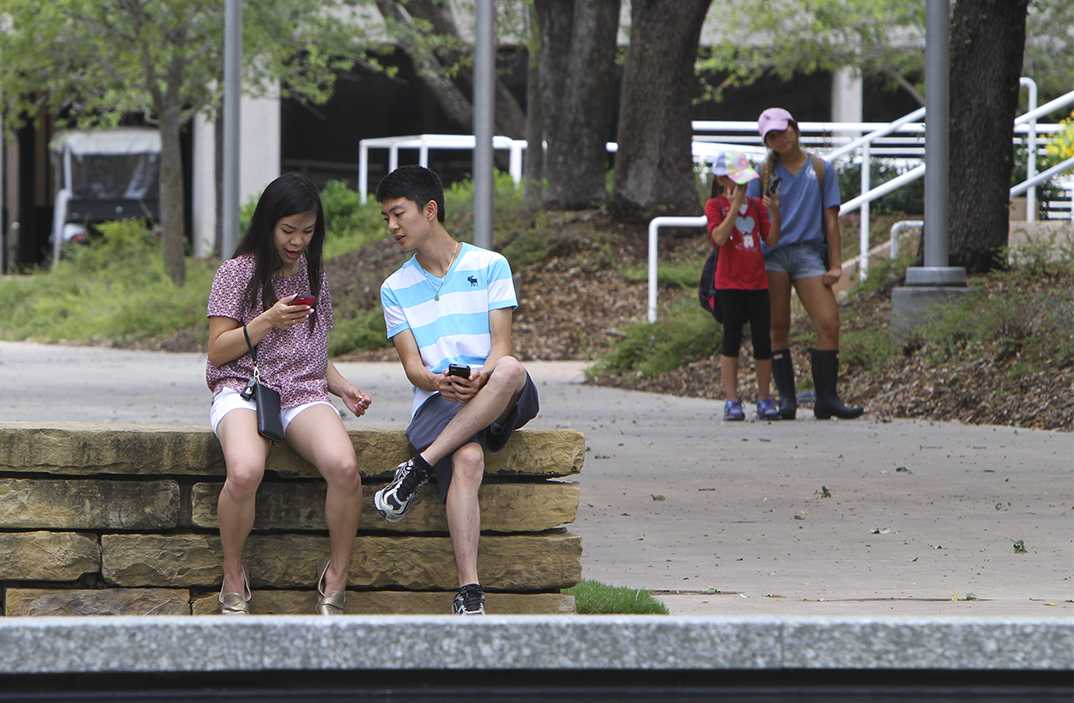Two students sit at the Plinth while playing "Pokemon Go." Nintendo released the game for Apple and Android on July 6.