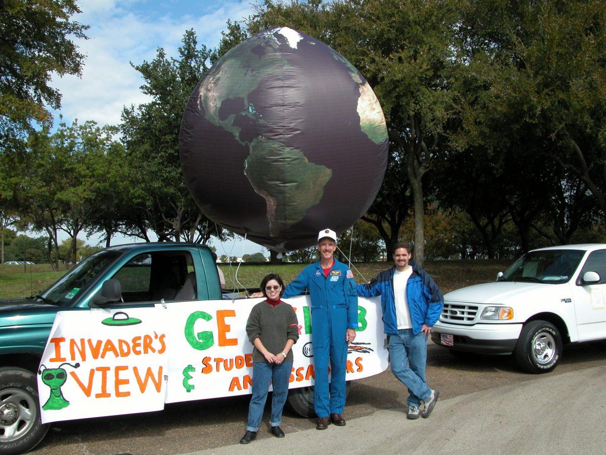 John Thurmond (right) was inspired by astronaut and alumnus Jim Reilly (center), whom he met while working on the geoscience Homecoming parade float. Thurmond is following in Reilly’s footsteps by applying for NASA’s astronaut program following his long career in the oil industry. (John Thurmond | Courtesy)