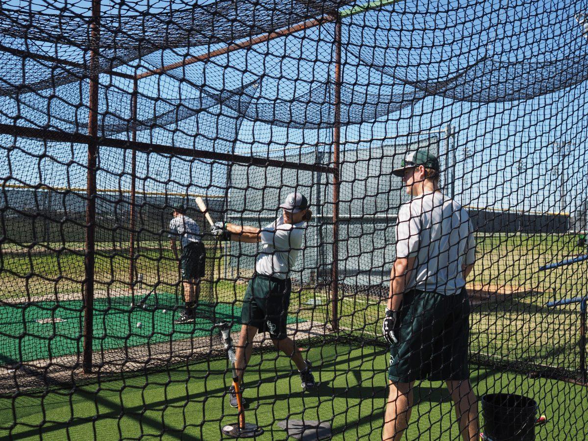 John-Paul Weber (left), a sophomore outfielder, practices in the new batting cage facilities with Griffin Mavis, a sophomore catcher. The cages were completed on Sept. 26 and cost approximately $20,000. Head coach Shawn Shewmake said the upcoming press box cost about $125,000 and will be opening soon. Photo by Roman Soriano | Mercury Staff.