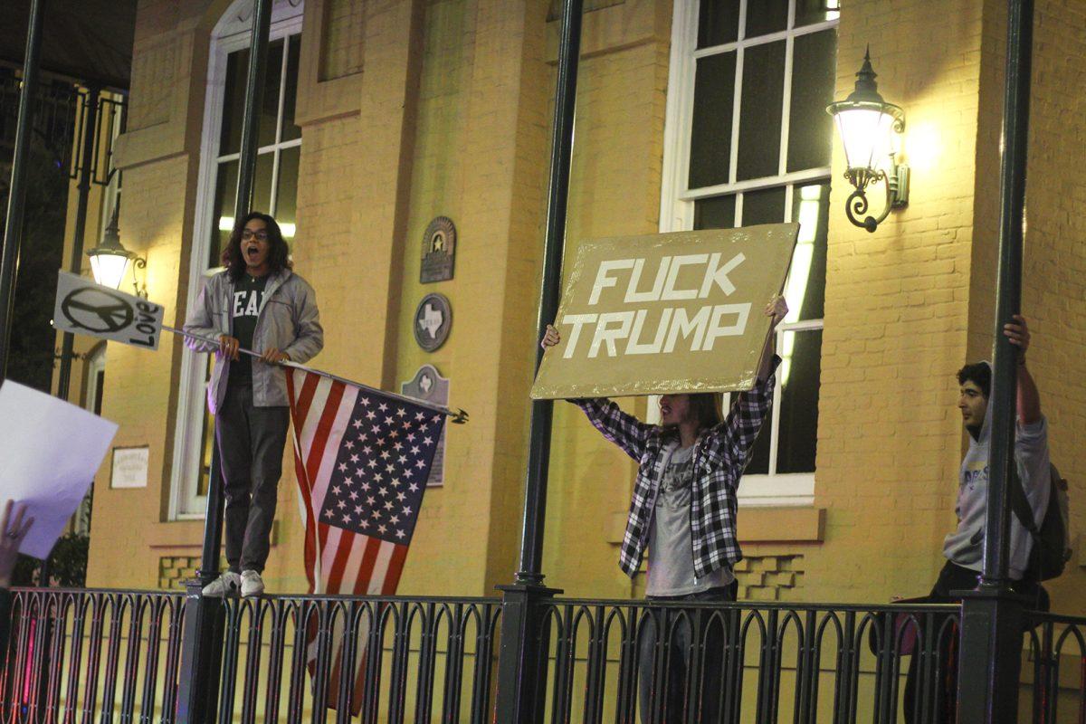 Participants stood with signs and flags at the protest against President-elect Donald Trump on Nov. 9. The rally marched through uptown and dowtown Dallas. Photo by Esteban Bustillos | Mercury Staff.
