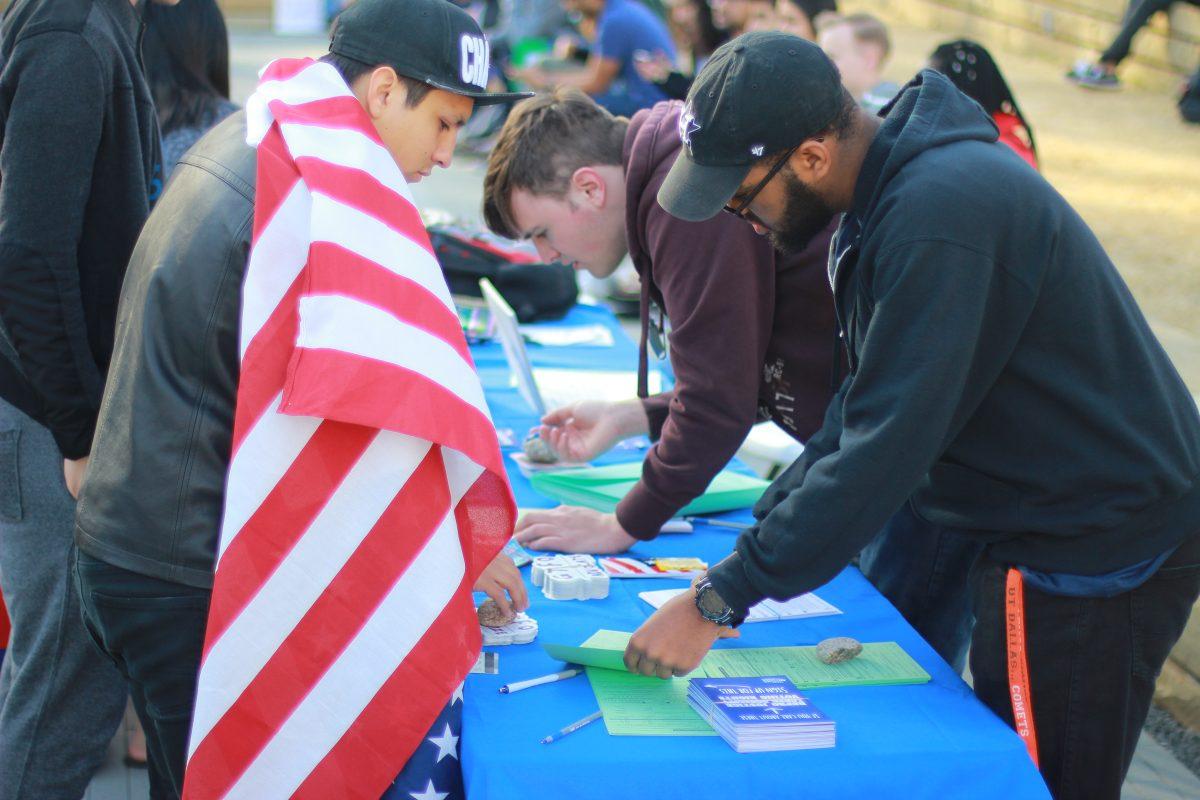 Christian Briggs (center), the president of Texas Rising at UTD and a computer science junior, helps students register to vote at the ‘We Are UTD’ event on Feb. 8. Photo by Ankith Averineni | Mercury Staff.