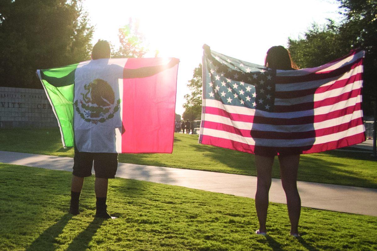 Historical studies sophomore Ociel Galindo (left) and international political economy junior Mercedes Molina wear the Mexican and American flags at a rally on Sept. 13 to show solidarity with undocumented students. Photo by Valerie Perez | Mercury Staff.