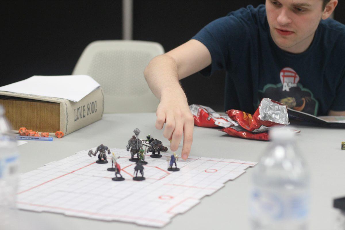 Justin Burch, a freshman studying computer science, maneuvers his pieces during a UTD-themed apocalyptic D&D game. Photo by Michael Stout | Mercury Staff.
