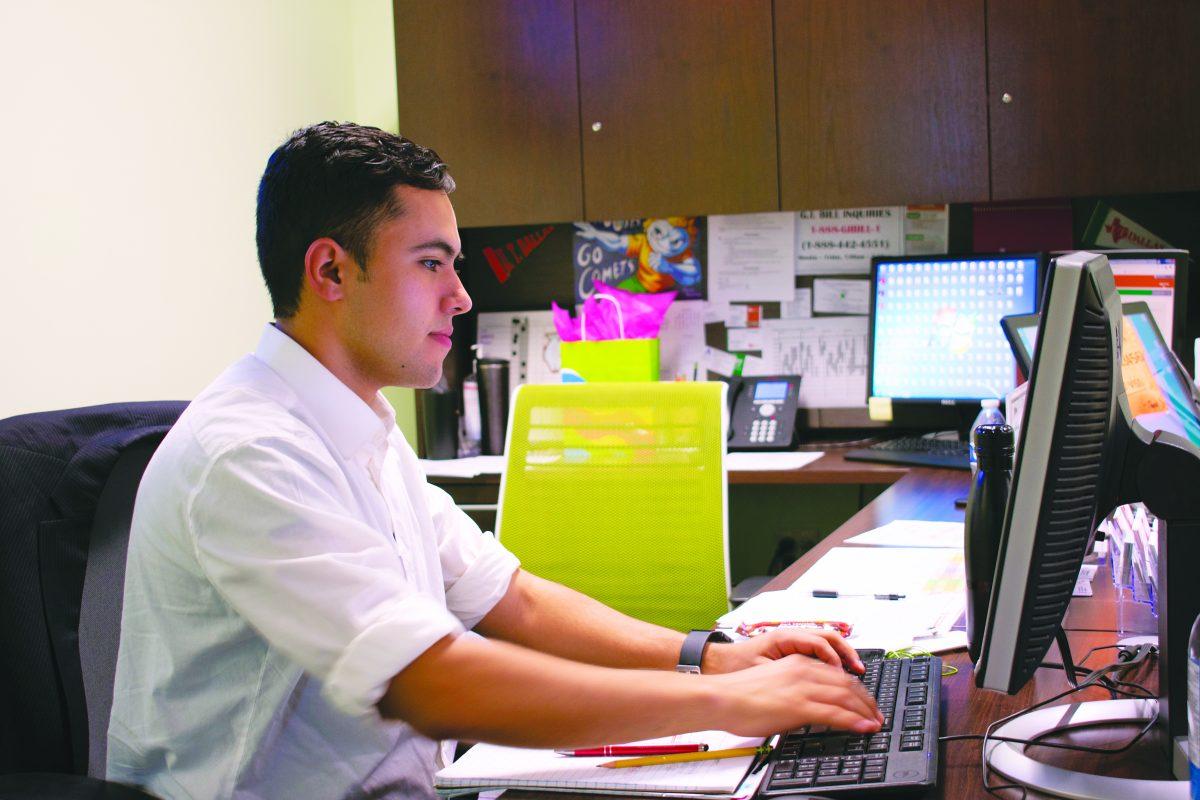 Student worker and supply chain management senior Cristobal Puga works at his desk at the Military and Veteran Center. Photo by Nadine Omeis | Mercury Staff.