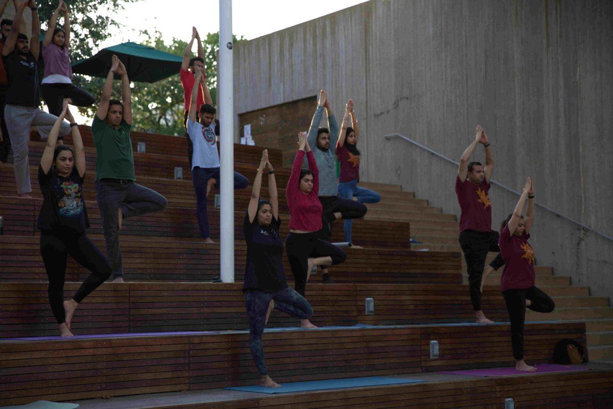 Participants doing  Vrukshasana — a tree pose which helps strengthen the ligaments in your feet.